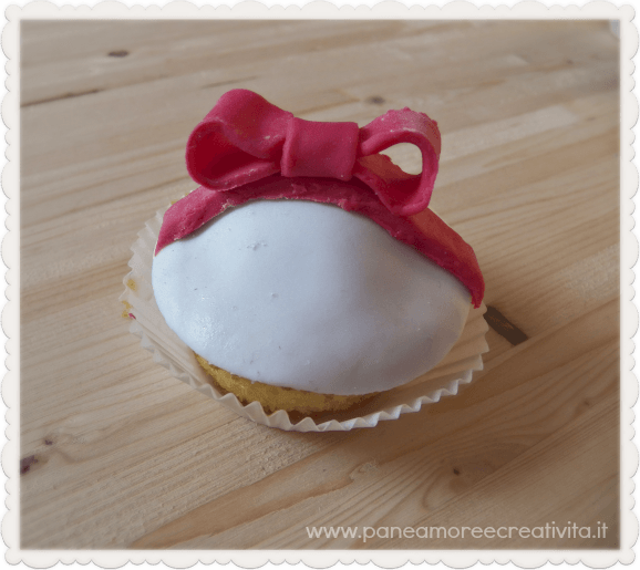 Natale in cucina: cupcake decorati con fiocco in pasta di zucchero